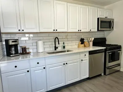 a kitchen with white cabinets and a sink at KING bed, Pet Friendly, Modern Retreat in CLE-BW in Berea