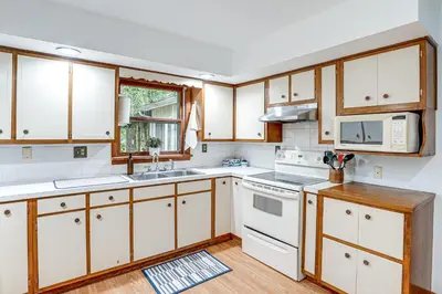 a kitchen with white appliances and wooden cabinets at Fish, Hike and Golf Countryside Retreat in Bluffton in Bluffton