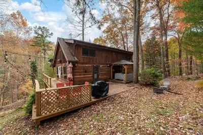 a cabin in the woods with a wooden fence at Outdoors Sleeps7 Family Getaway Fun Arcade in Rockbridge
