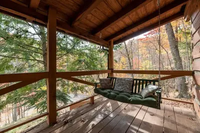 a porch with a green couch on a wooden deck at Outdoors Sleeps7 Family Getaway Fun Arcade in Rockbridge