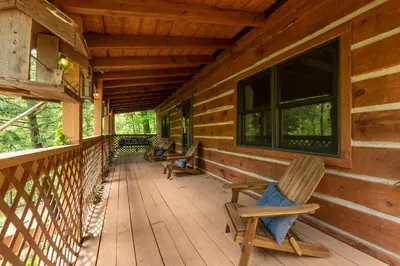 a porch of a log cabin with chairs on it at Outdoors Sleeps7 Family Getaway Fun Arcade in Rockbridge
