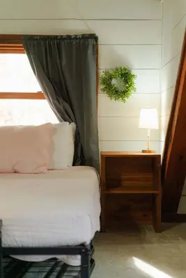 a bedroom with a bed and a lamp and a window at Outdoors Sleeps7 Family Getaway Fun Arcade in Rockbridge
