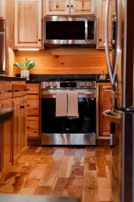 a kitchen with a black oven and a microwave at Sleeps 16! Luxury Cabin with Game Room & Hot Tub in Nelsonville