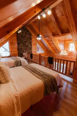 a bedroom with three beds in a room with wooden ceilings at Sleeps 16! Luxury Cabin with Game Room & Hot Tub in Nelsonville