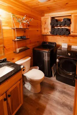 a bathroom with a toilet and a sink in a cabin at Sleeps 16! Luxury Cabin with Game Room & Hot Tub in Nelsonville
