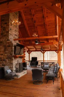a living room with couches and a brick wall at Sleeps 16! Luxury Cabin with Game Room & Hot Tub in Nelsonville