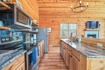 a large kitchen with wooden walls and wooden floors at Fern Haven A modern take on Hocking Hills cabins in McArthur