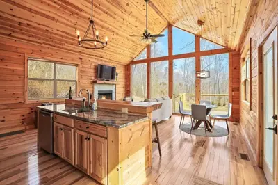 a kitchen and dining room of a log cabin at Fern Haven A modern take on Hocking Hills cabins in McArthur