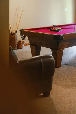 a pool table in a living room with a chair at Cheerful Two Bdrm Cabin with Hot Tub & Pet Friendly in Lancaster