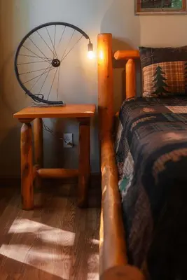 a bedroom with a bed and a table with a bicycle tire on it at Cheerful Two Bdrm Cabin with Hot Tub & Pet Friendly in Lancaster