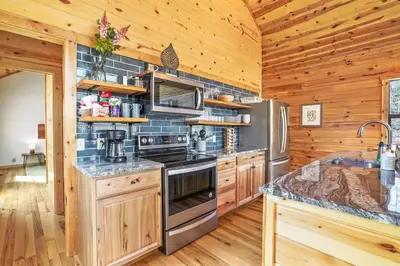 a kitchen with wooden cabinets and a stove top oven at Modern Luxury I Hot Tub I Hiking in McArthur