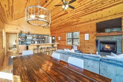 a living room with a fireplace and a dining room at Modern Luxury I Hot Tub I Hiking in McArthur
