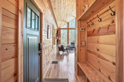 a hallway in a wooden house with a door at Modern Luxury I Hot Tub I Hiking in McArthur