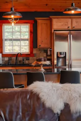 a kitchen with a table with chairs and a refrigerator at COZY Cabin with Hot Tub - Near all in Hocking Hills in Logan