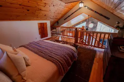 a bedroom with a large bed in a cabin at COZY Cabin with Hot Tub - Near all in Hocking Hills in Logan