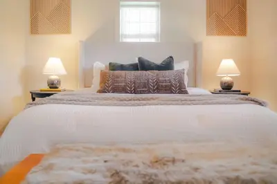 a bedroom with a large white bed with two lamps at COZY Cabin with Hot Tub - Near all in Hocking Hills in Logan