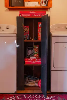 a cupboard in a kitchen next to a washing machine at COZY Cabin with Hot Tub - Near all in Hocking Hills in Logan