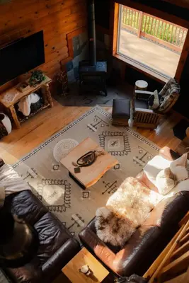 a living room with a leather couch and a rug at COZY Cabin with Hot Tub - Near all in Hocking Hills in Logan