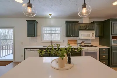 a kitchen with green cabinets and a white counter top at Buckingham Woods I Hocking Hills in Logan