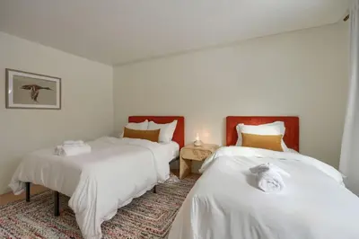 a bedroom with two beds with white sheets and a rug at Buckingham Woods I Hocking Hills in Logan
