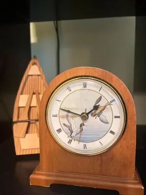 a clock sitting on a table next to a wooden boat at Blue Heron Cottage with Game Room, Deck & Hot Tub in Logan