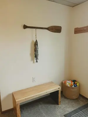 a room with a wooden bench and a stick on the wall at Blue Heron Cottage with Game Room, Deck & Hot Tub in Logan