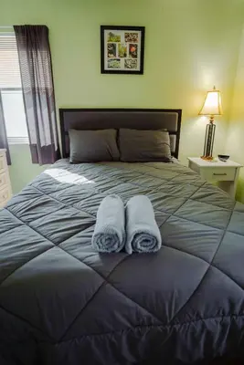 a bedroom with a large bed with two towels on it at Blue Heron Cottage with Game Room, Deck & Hot Tub in Logan