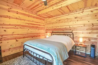 a bedroom with a bed in a log cabin at Fern Woods A modern take on Hocking Hills cabins in McArthur