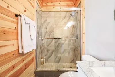 a bathroom with a shower and a toilet at Fern Woods A modern take on Hocking Hills cabins in McArthur