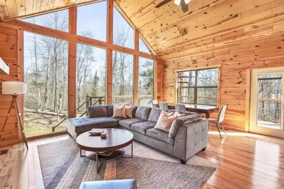 a living room with a couch and a table at Fern Woods A modern take on Hocking Hills cabins in McArthur