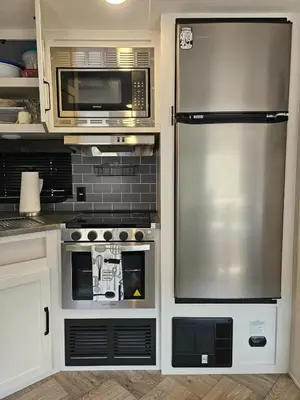 a kitchen with a stainless steel refrigerator and microwave at Tranquil Stay Close to Hotspots