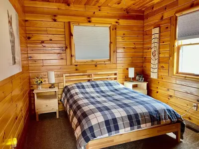 a bedroom with a bed in a wooden cabin at Fern Hill Cabin in McArthur