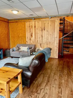 a living room with a leather couch and a table at Fern Hill Cabin in McArthur