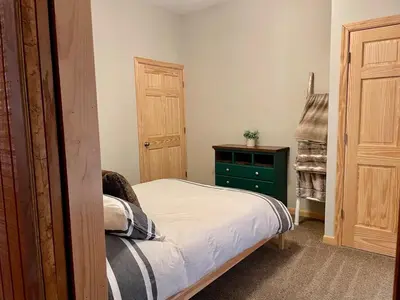 a small bedroom with a bed and a green dresser at Fern Hill Cabin in McArthur