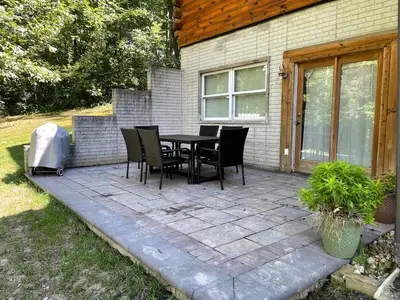 a patio with a table and chairs next to a house at Fern Hill Cabin in McArthur