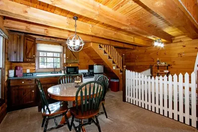 a kitchen and dining room with a table and chairs at Honey Bear Cabin in Millersburg