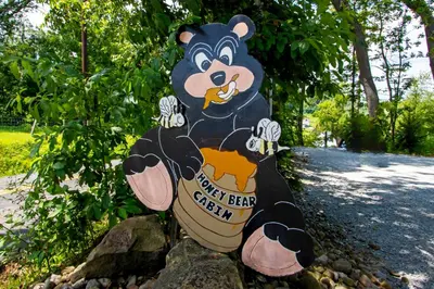 a sign with a mickey bear on it at Honey Bear Cabin in Millersburg