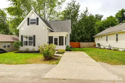 a white house with a driveway in a yard at Modern Comfort Near Columbus Home with Yard and Porch in London