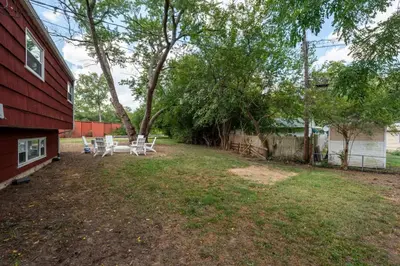 a yard with chairs and a tree and a house at Spacious 5BR Firepit with Deck Near OSU and More in Columbus