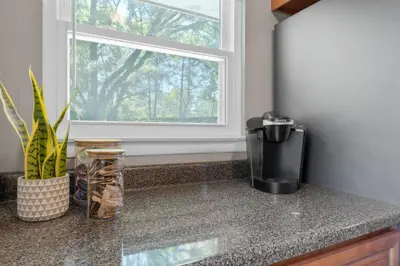 a kitchen counter with a coffee maker and a window at Spacious 5BR Firepit with Deck Near OSU and More in Columbus