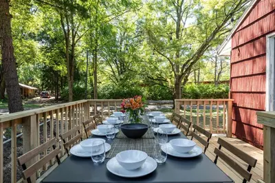 a black table with white plates and bowls and flowers at Spacious 5BR Firepit with Deck Near OSU and More in Columbus