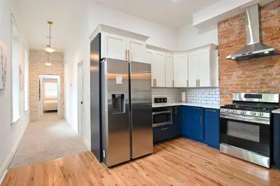a kitchen with blue cabinets and a stainless steel refrigerator at 2BR Townhome - Free Parking, Minutes to Stadiums in Covington