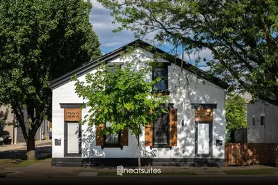 a white house with a tree in front of it at Two Condos for 14 Guests, 5 Bedrooms, Free Parking in Covington
