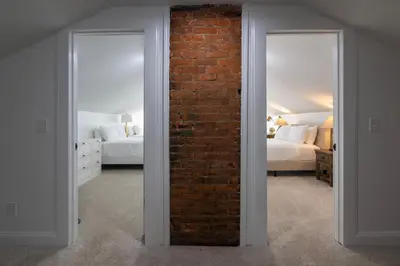 a room with a brick wall and two beds at Two Condos for 14 Guests, 5 Bedrooms, Free Parking in Covington
