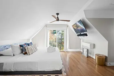 a white bedroom with a bed and a tv at 1BR, Next to Monastery Wedding Venue, with Bathtub in Cincinnati
