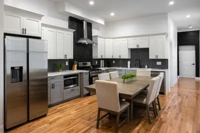 a kitchen with a table with chairs and a refrigerator at 3 Bedroom Condo - Close to Stadiums & Downtown in Covington