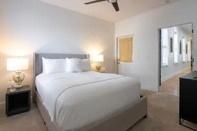 a white bedroom with a large bed and two lamps at 3 Bedroom Condo - Close to Stadiums & Downtown in Covington