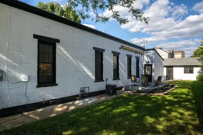a white building with a yard next to a house at 3 Bedroom Condo - Close to Stadiums & Downtown in Covington