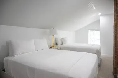 two white beds in a white bedroom with a window at 3 Bedroom Condo - Close to Stadiums & Downtown in Covington