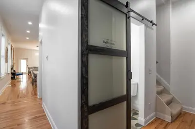a sliding barn door in a hallway with a living room at 3 Bedroom Condo - Close to Stadiums & Downtown in Covington